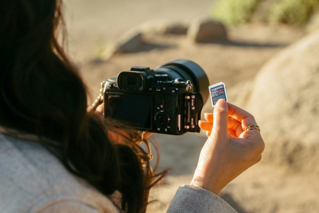 Woman inserting memory card into camera