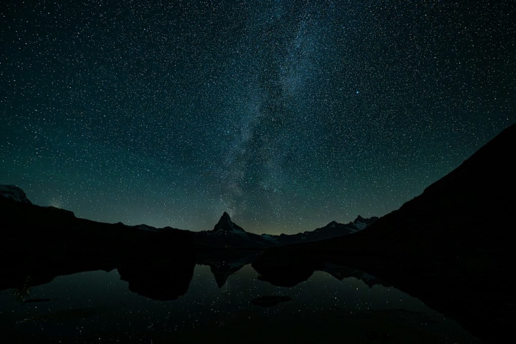Starry night sky reflected in a calm lake